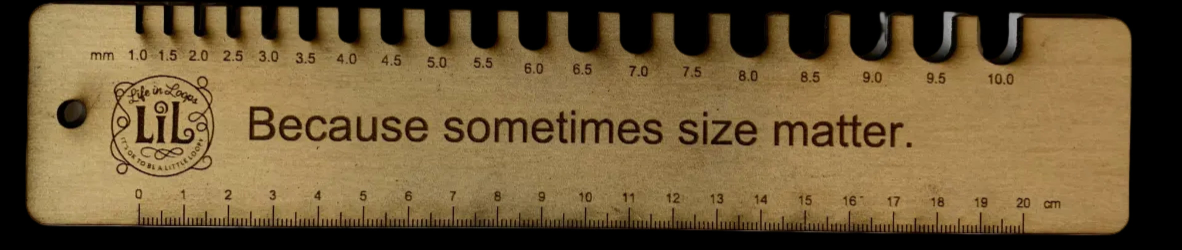 Wooden ruler with text 'Because sometimes size matters' on a white background