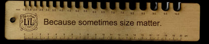 Wooden ruler with text 'Because sometimes size matters' on a white background